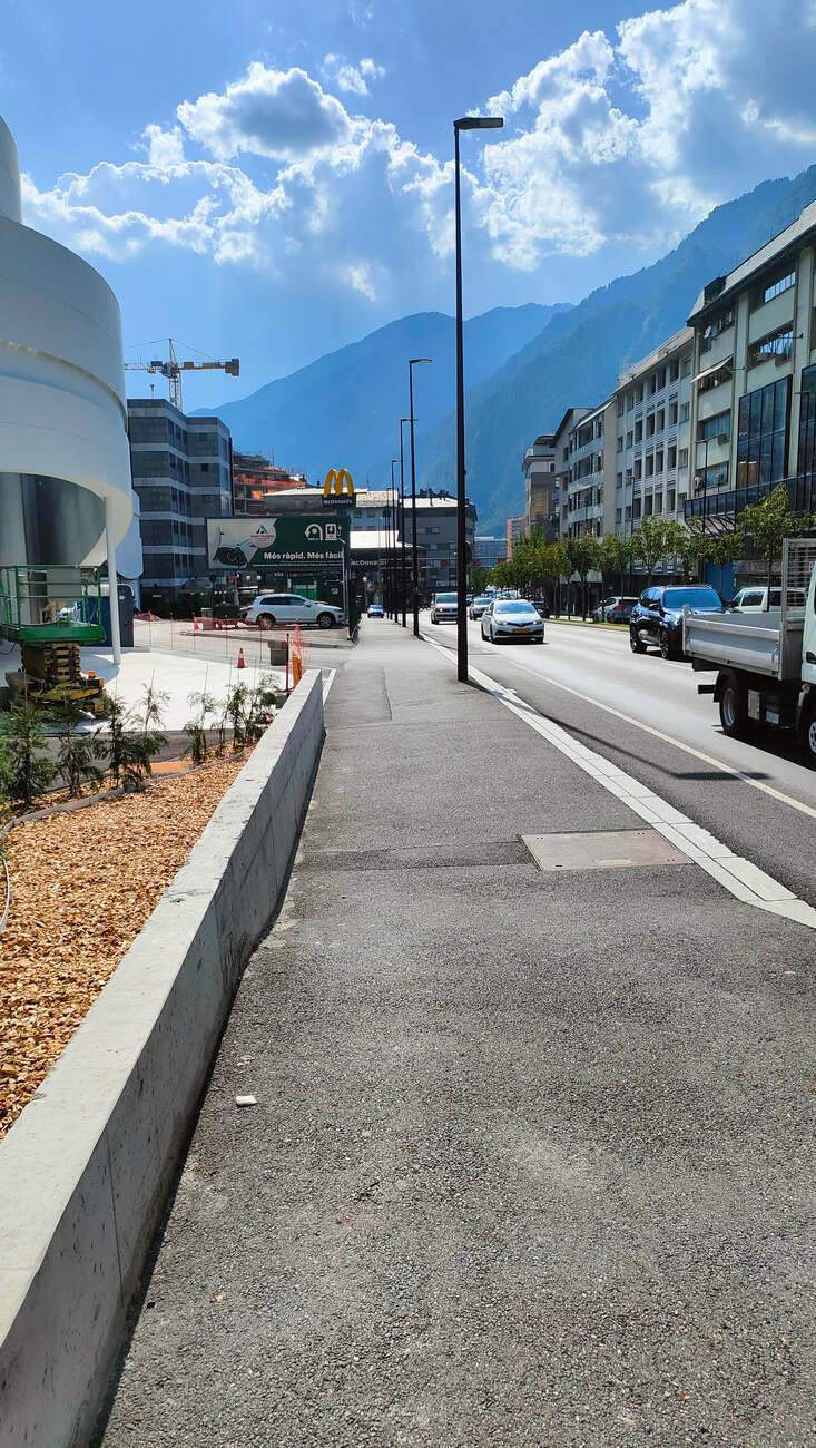 Anfahrt zur Ladestation von der anderen Seite, im Hintergrund Berge und ein McDonald's-Schild