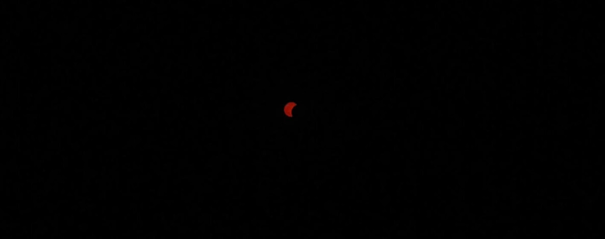 Stark verdunkelte, sichelförmige Sonne während der Sonnenfinsternis