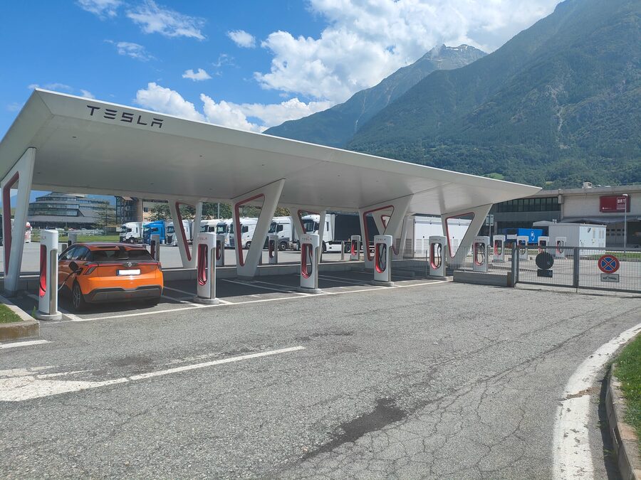 Fremdmarke lädt an Tesla Supercharger in Norditalien – Alpenpanorama im Hintergrund